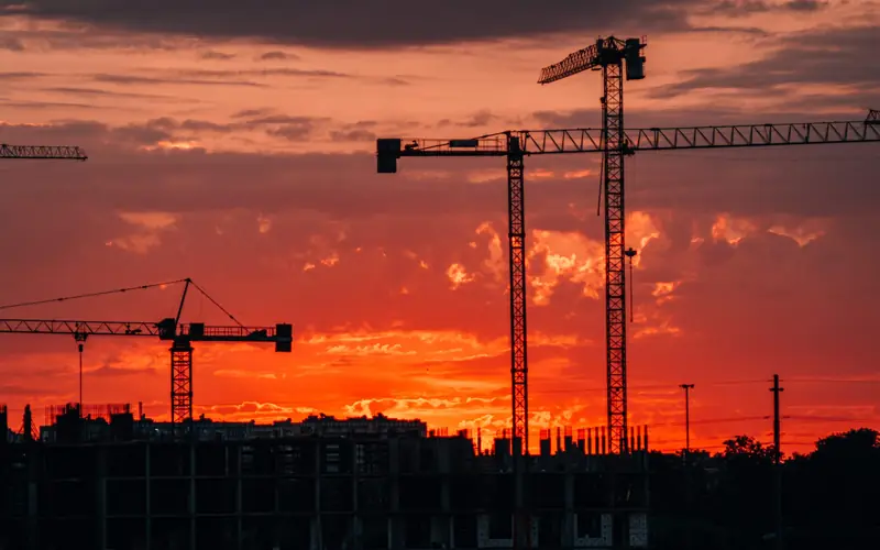 Grues de chantier au coucher du soleil
